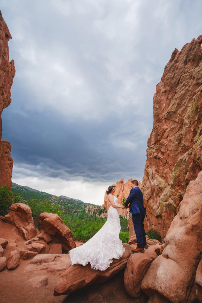 Colorado elopement photographer shares wedding regrets from couple in the red rocks standing between two large boulders 