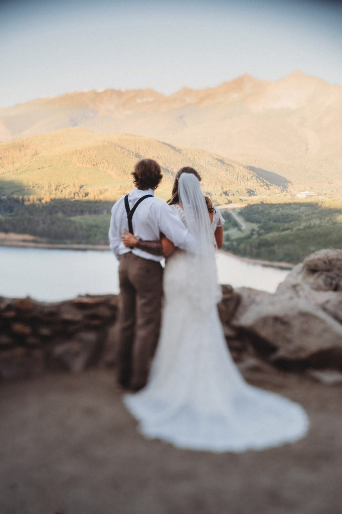 Colorado elopement photographer captures bride and groom looking over at mountains 