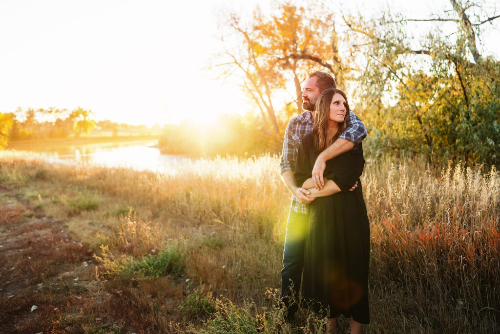 couple hugging in meadow in colorado with beautiful fall colors
