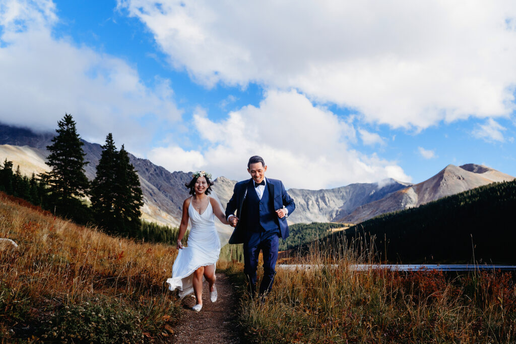 Colorado elopement photographer captures couple running during bridal portraits after elopement