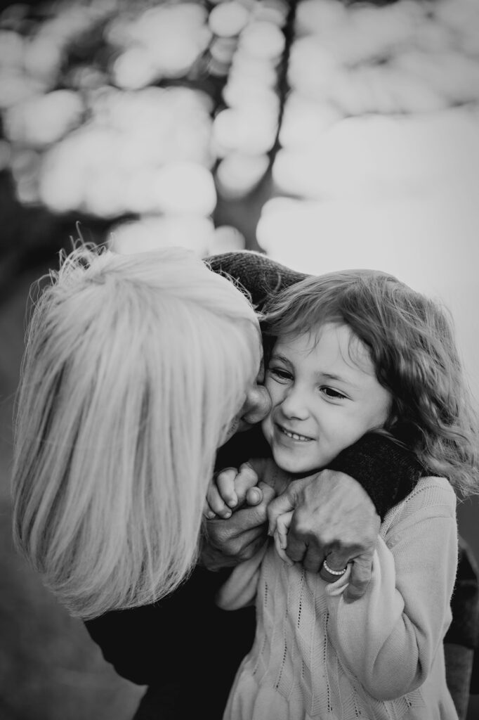 Grandma cuddling grandchildren during outdoor family photos