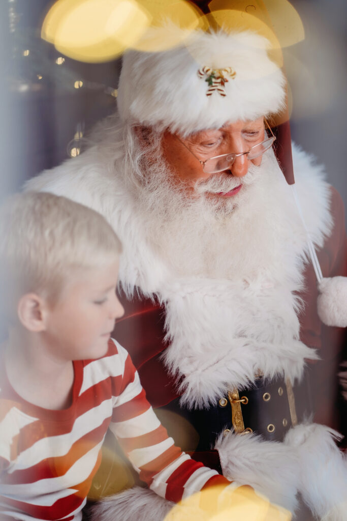 Denver Family Photographer captures child sitting with santa reading a book