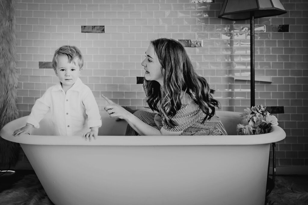 unique mothers day gifts of motherhood photos with mother and little boy sitting in a bath tub together in a studio space