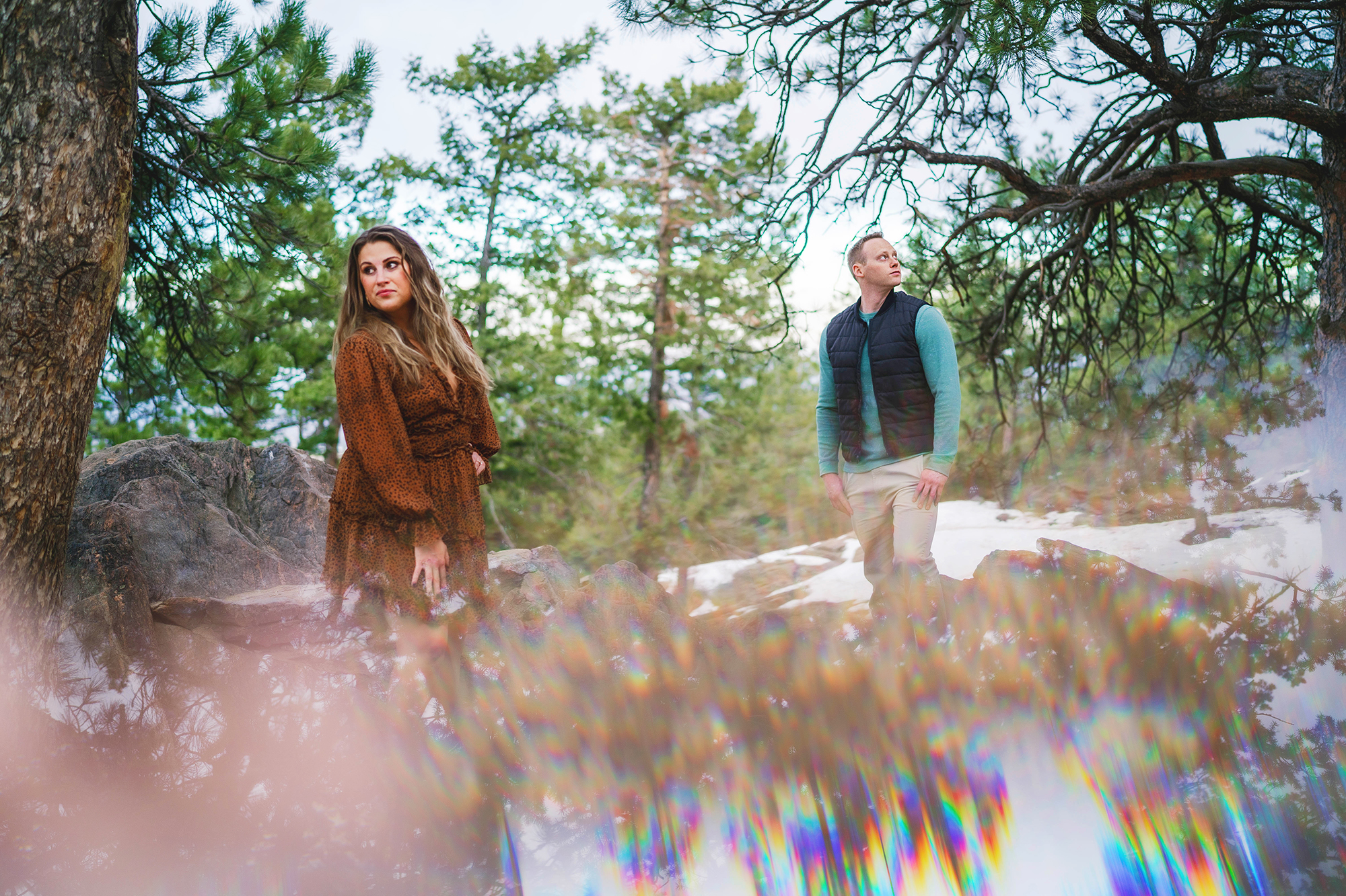 colorado elopement photographer photographs unique engagement photos in the Rockies with man and woman standing in the forest of the mountains looking opposite directions with a reflective edit