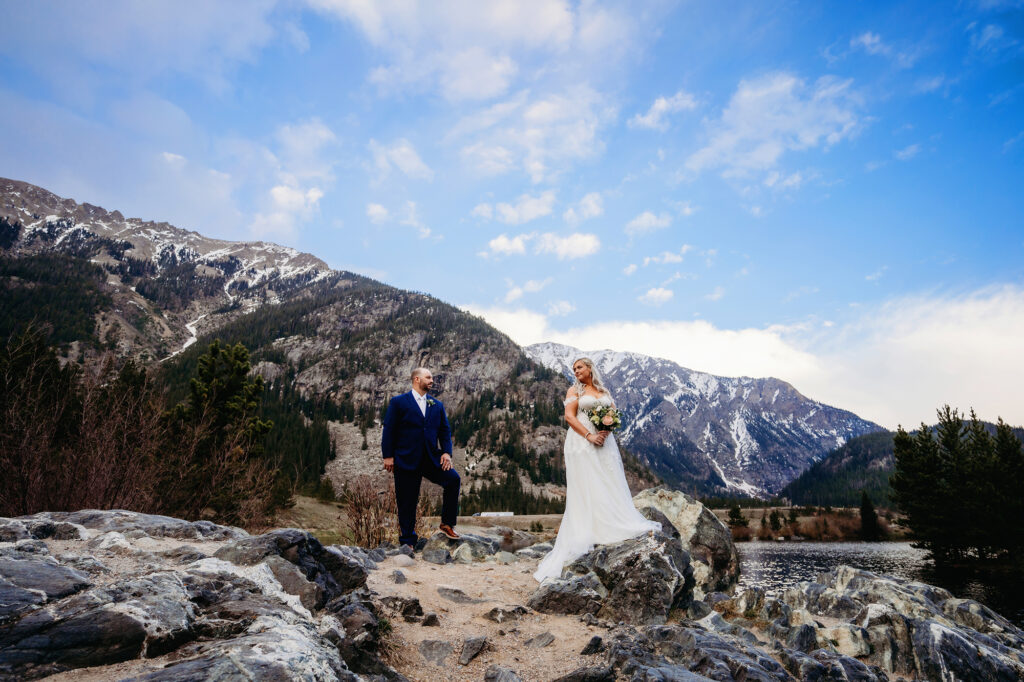 Colorado elopement photographer captures newly married couple standing together in Colorado mountains in wedding attire