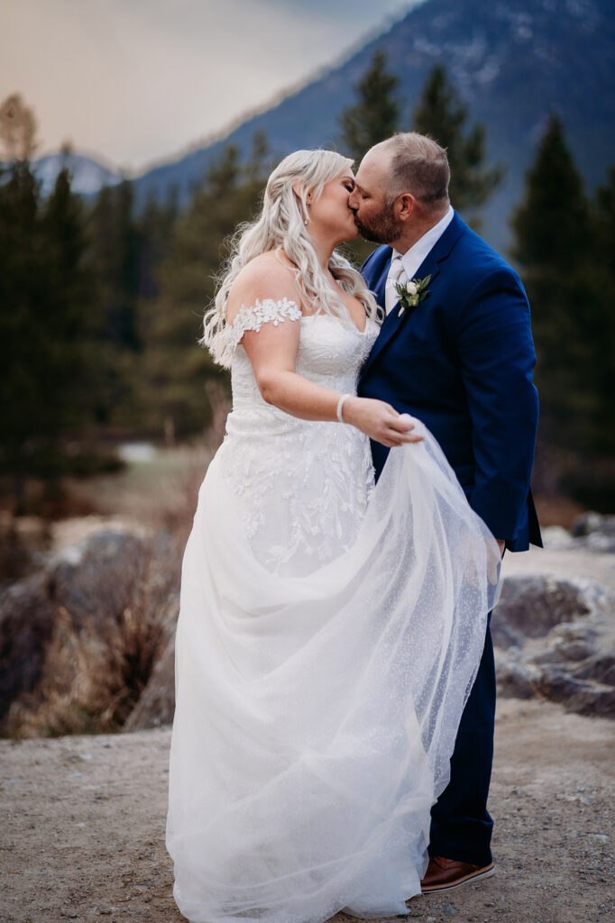 Colorado elopement photographer captures newly married couple kissing in wedding attire in Colorado mountains