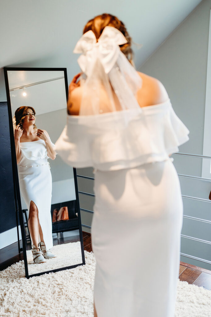 Colorado elopement photographer captures bride in wedding gown looking in mirror