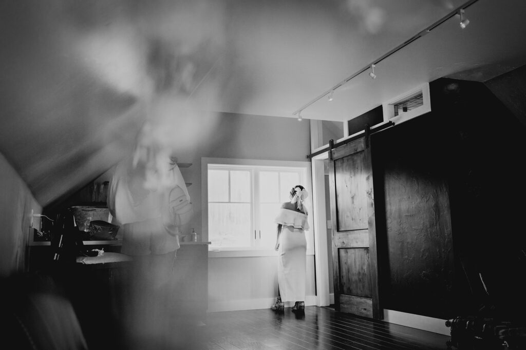 Colorado elopement photographer captures black and white portrait of bride looking outside window