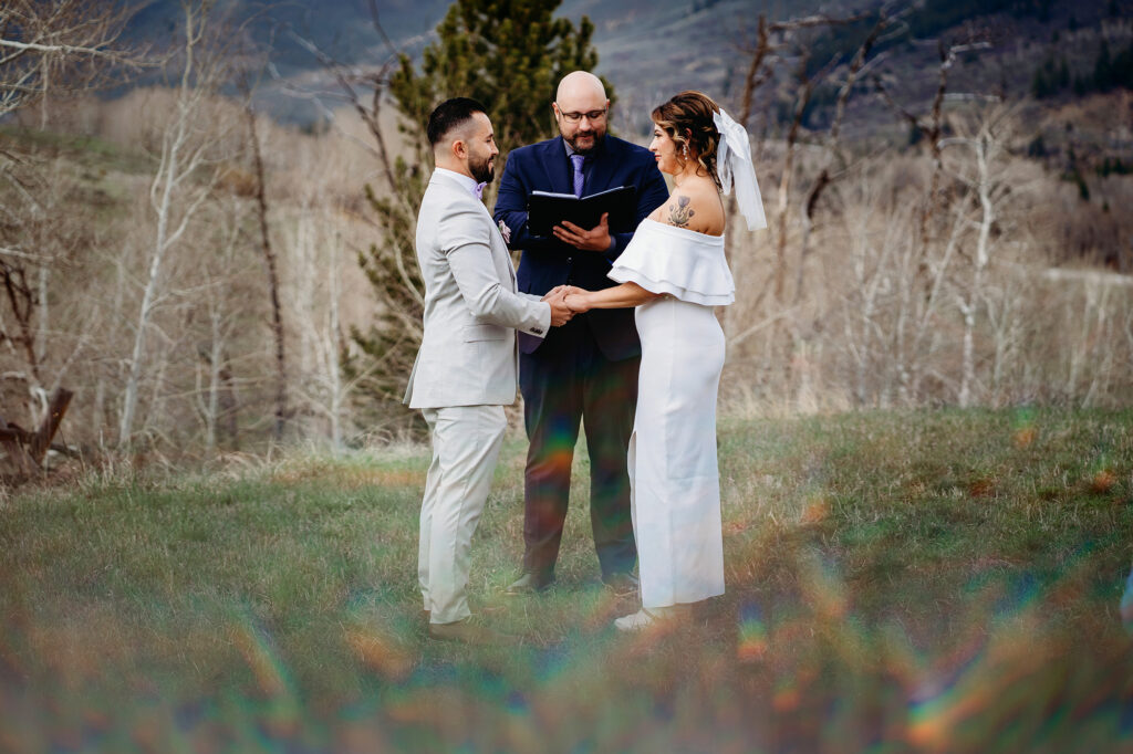 Colorado elopement photographer captures bride and groom holding hands during elopement ceremony