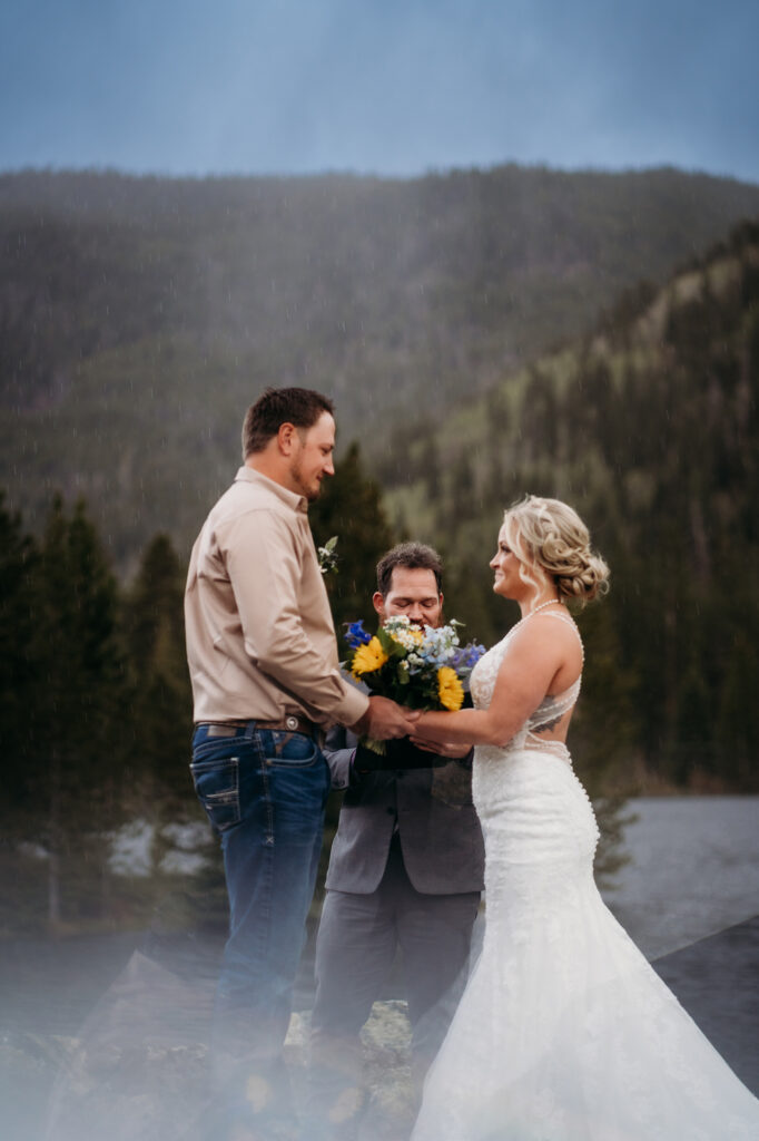 Denver wedding photographer captures bride and groom holding hands during vows