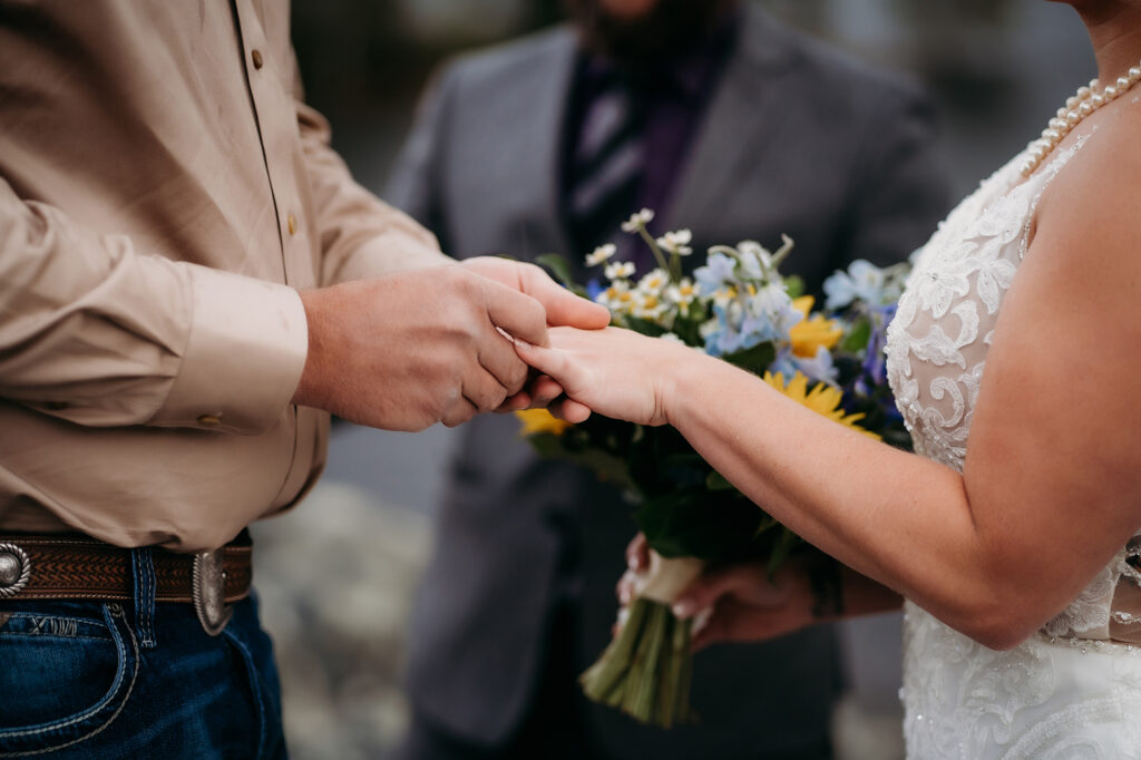 Denver wedding photographer captures groom putting ring on bride's finger