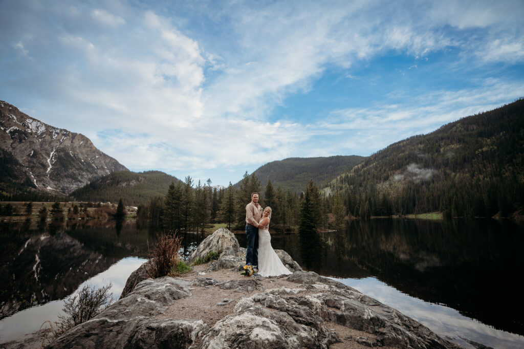 Denver wedding photographer captures couple embracing on rock during bridal portraits