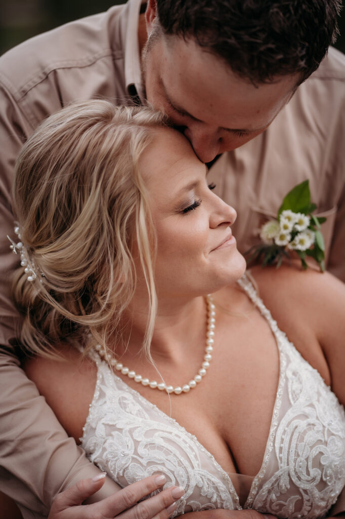 Denver wedding photographer captures groom kissing bride's forehead
