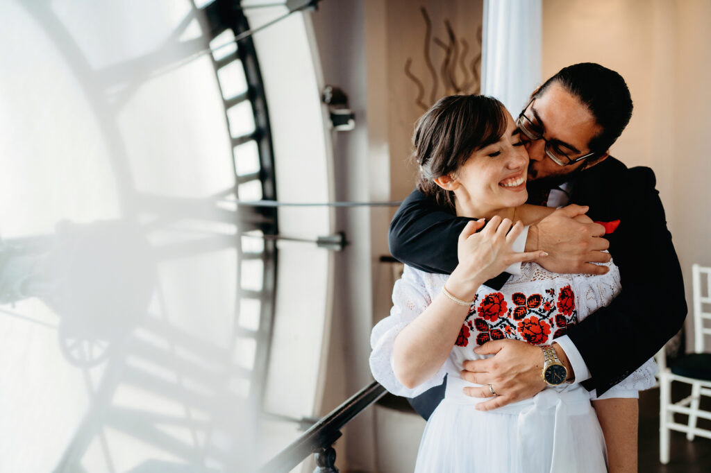 Colorado elopement photographer captures bride and groom embracing at clock tower