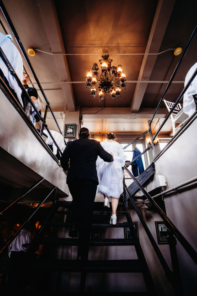 Colorado elopement photographer captures bride and groom walking upstairs together as husband and wife