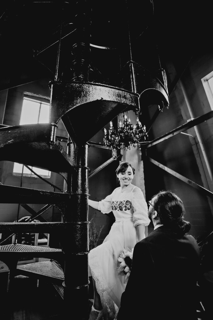 Colorado elopement photographer captures bride leading groom up to clock tower after elopement ceremony
