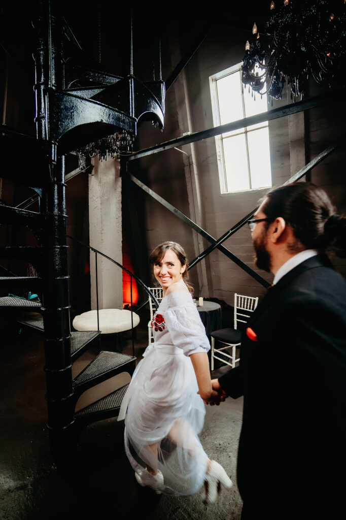 Colorado elopement photographer captures bride leading groom up to clock tower