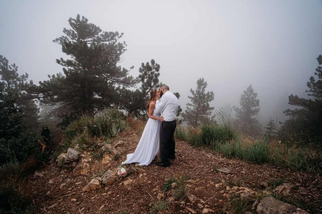 Colorado elopement photographer captures couple hugging during foggy outdoor bridal portraits