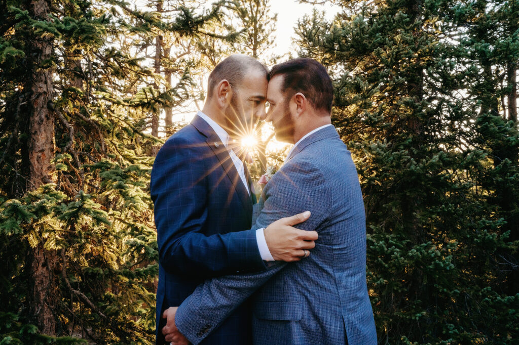 Colorado elopement photographers capture husbands hugging and touching foreheads during golden hour portraits