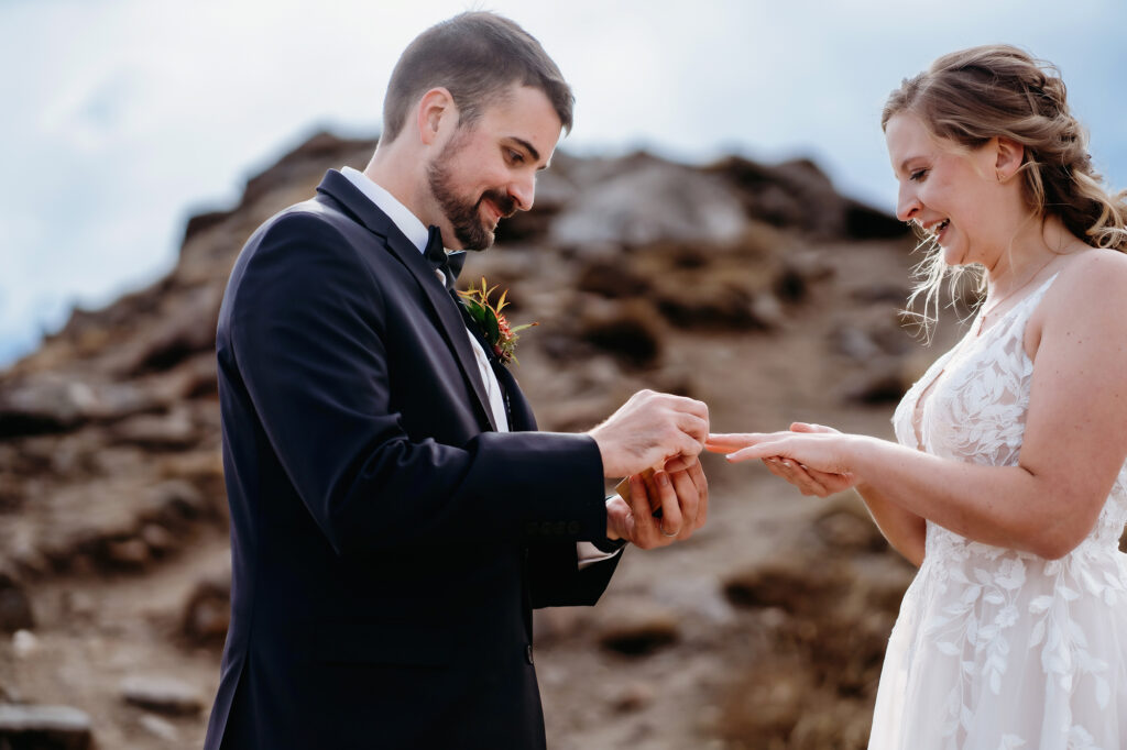 Colorado elopement photographer captures groom putting ring on bride's finger