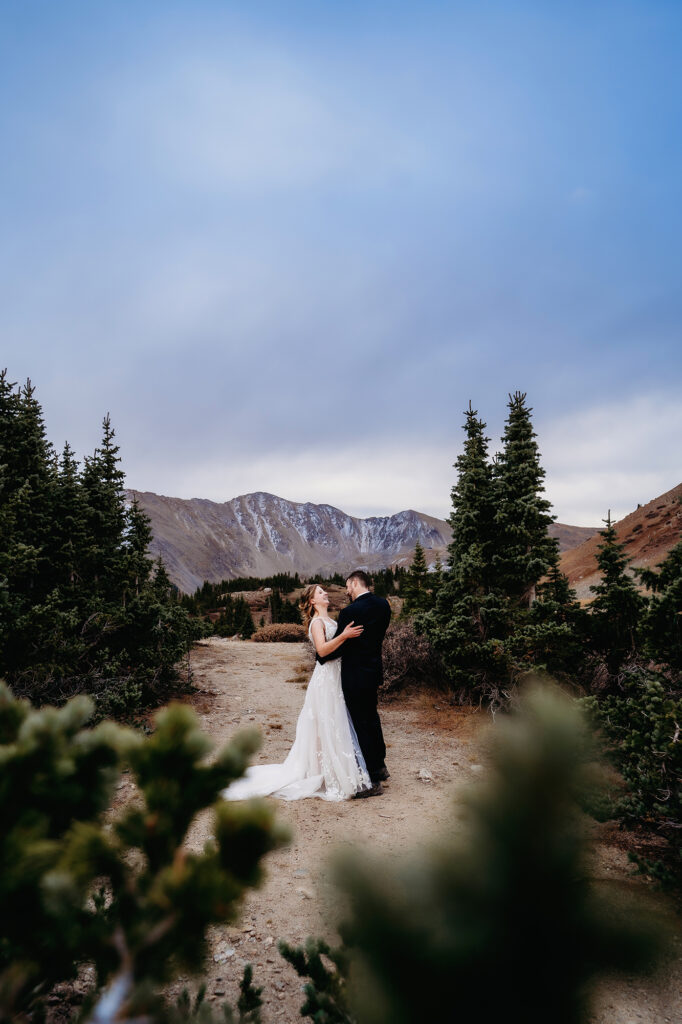 bride and groom dancing in the woods for their Colorado elopement right after sunset while laughing 