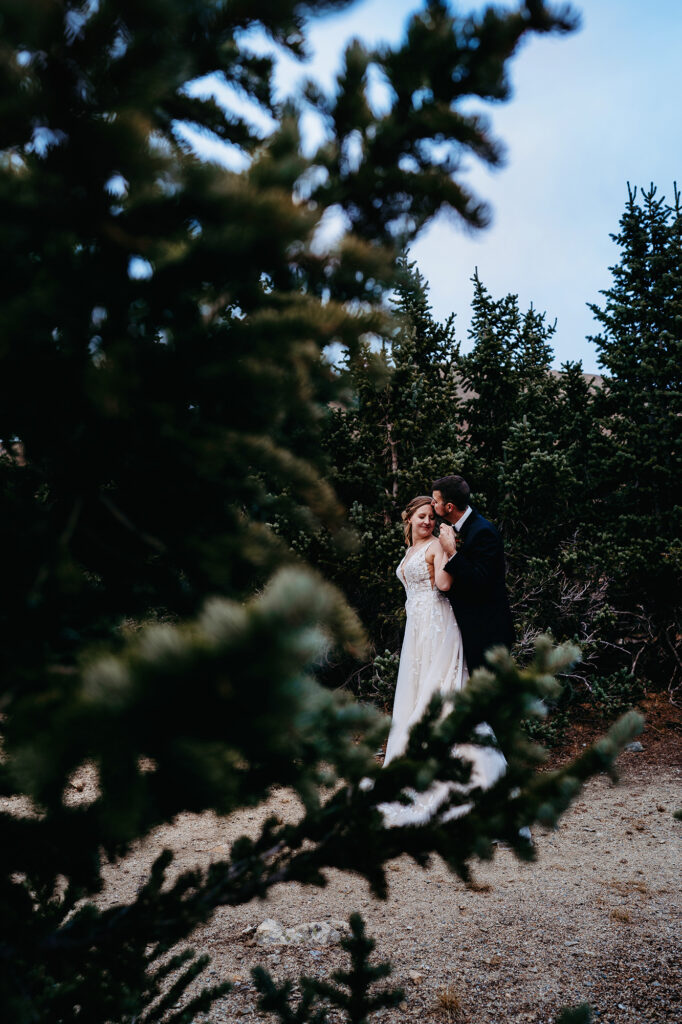 Colorado elopement photographer captures couple kissing in forest during outdoor bridals