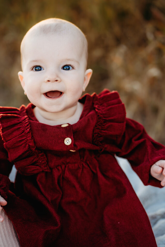 Denver family photographers capture little girl wearing red dress smiling