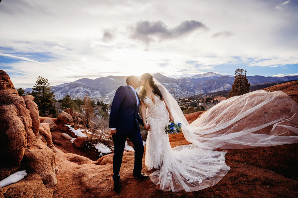 Colorado elopement photographer captures bride and groom kissing on red rock 