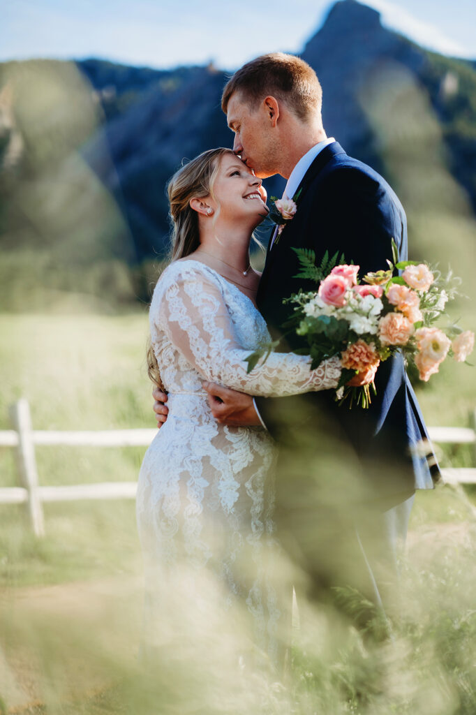Colorado elopement photographer captures groom kissing bride's forehead 