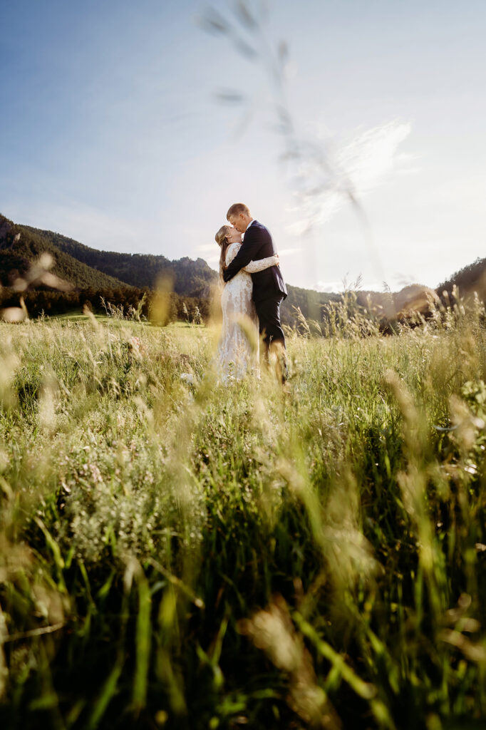 Colorado elopement photographer captures couple hugging in meadow during bridal portraits