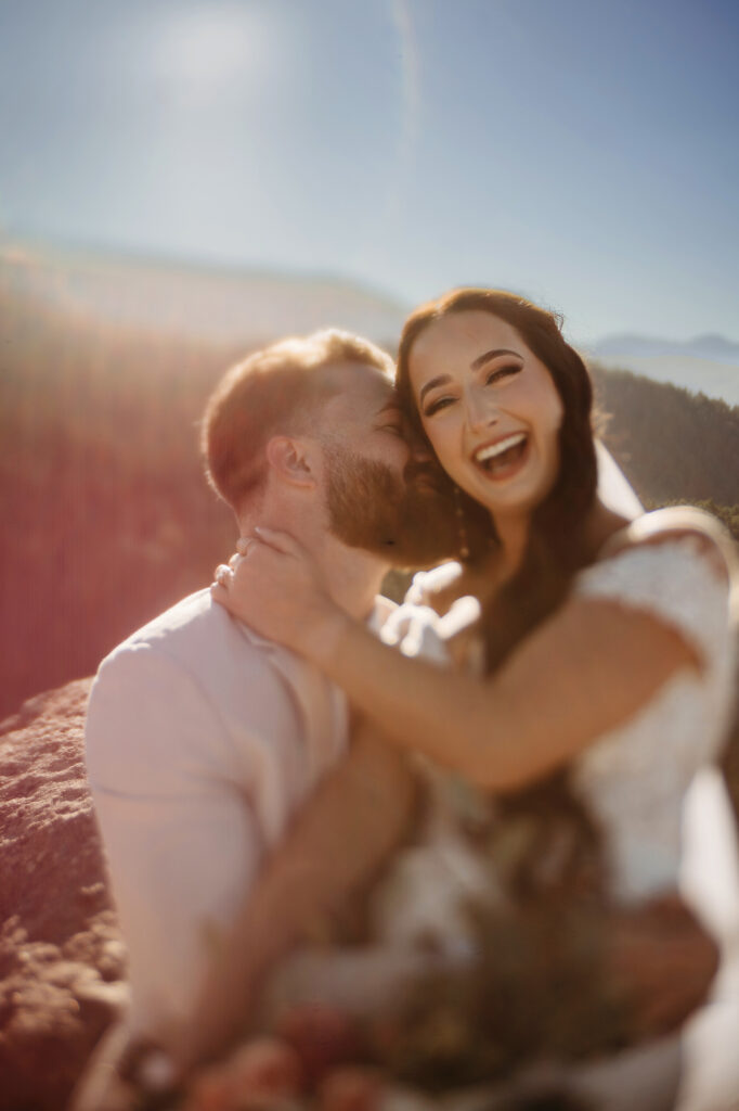 Colorado elopement photographer captures bride laughing while sitting on groom's lap