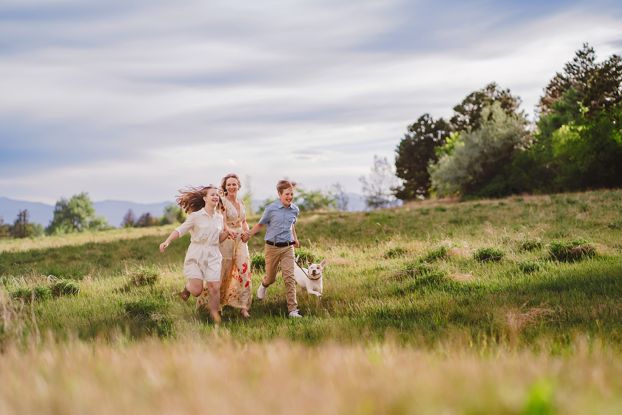 Denver family photographers capture family running through grass during spring family photos