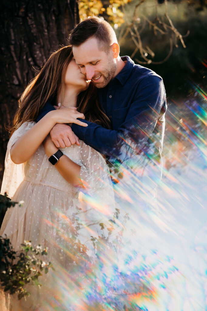 Denver family photographers capture couple kissing in sunlight
