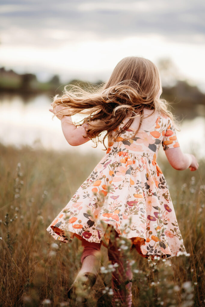 Denver family photographers capture young girl running through grass