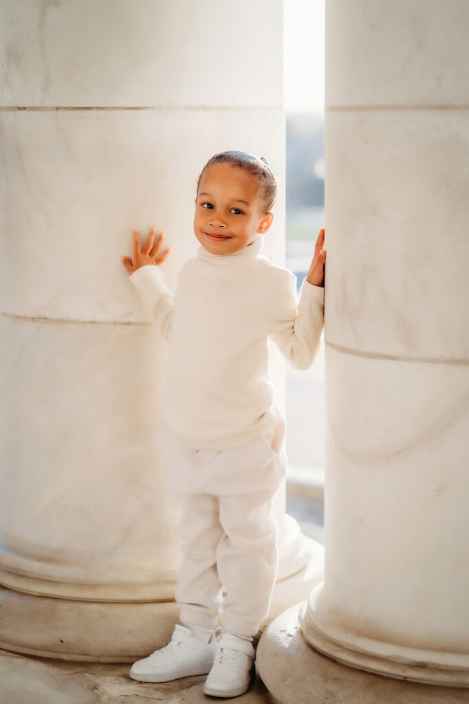 Denver family photographer captures young boy standing between pillars