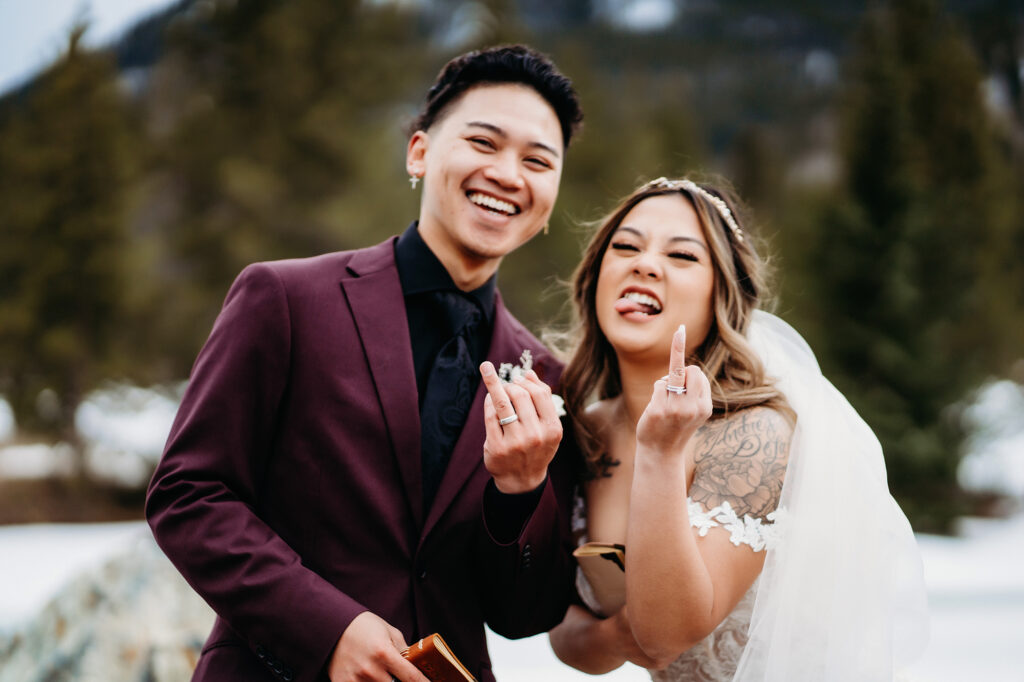 Colorado elopement photographer captures bride and groom sticking up ring fingers to show wedding rings