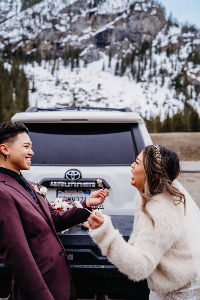 Colorado elopement photographer captures newly married couple eating wedding cake after destination elopement