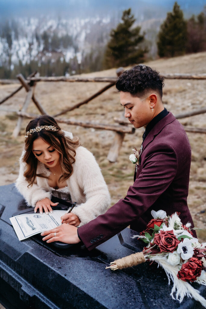 Colorado elopement photographer captures bride and groom signing marriage license after destination elopement in Colorado