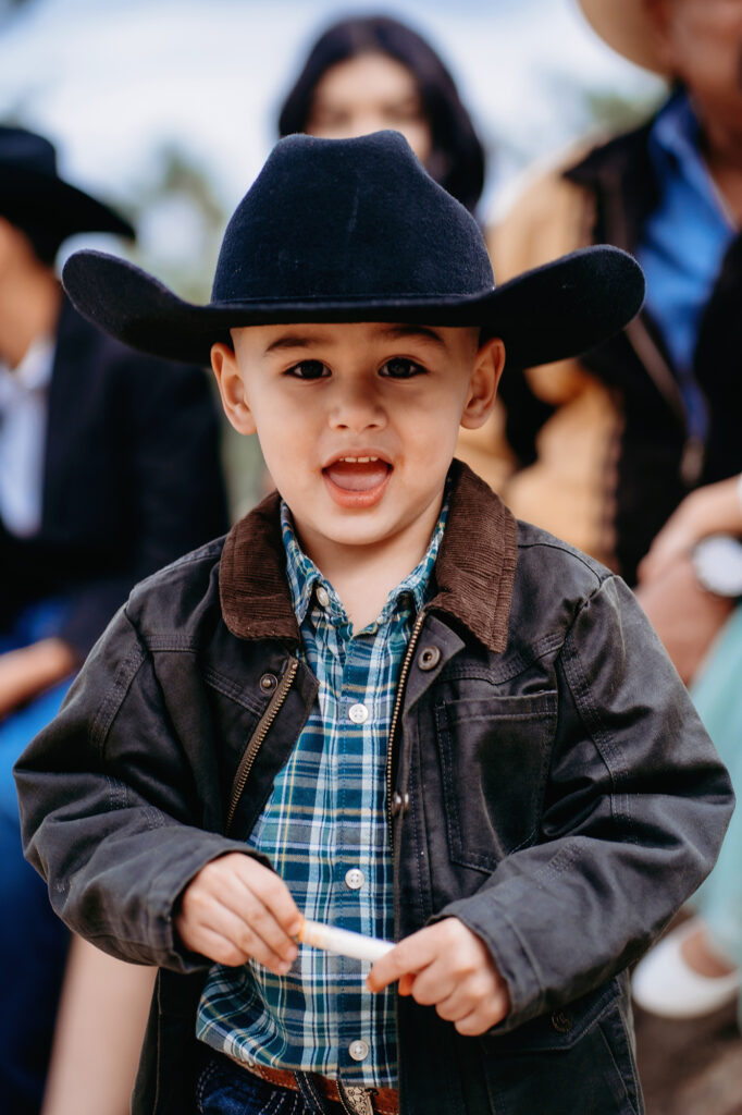 Colorado elopement photographer captures young boy wearing cowboy hat walking down the aisle