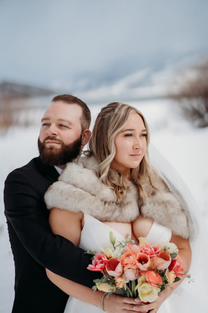 Colorado wedding photographer captures couple embracing while bride holds bridal bouquet