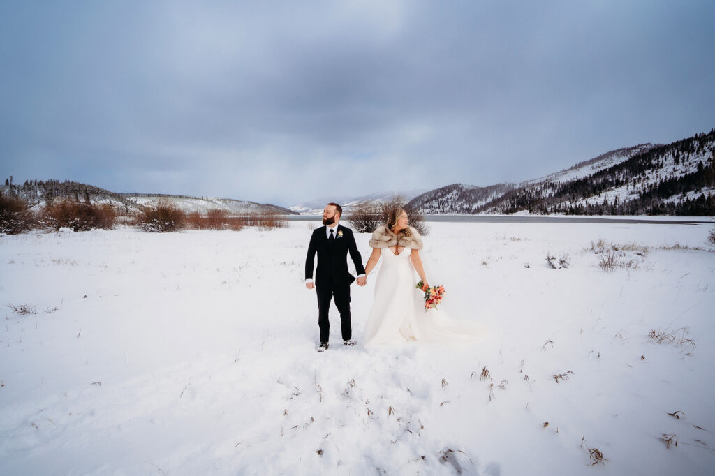 Colorado wedding photographer captures couple holding hands after snowy winter wedding