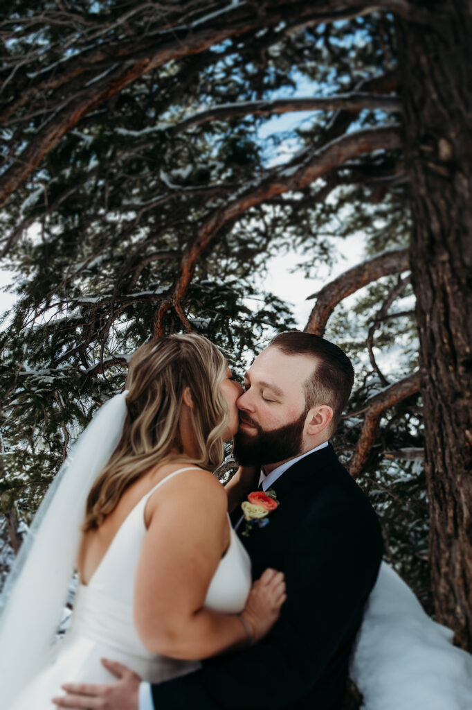 Colorado wedding photographer captures bride and groom kissing after winter wedding