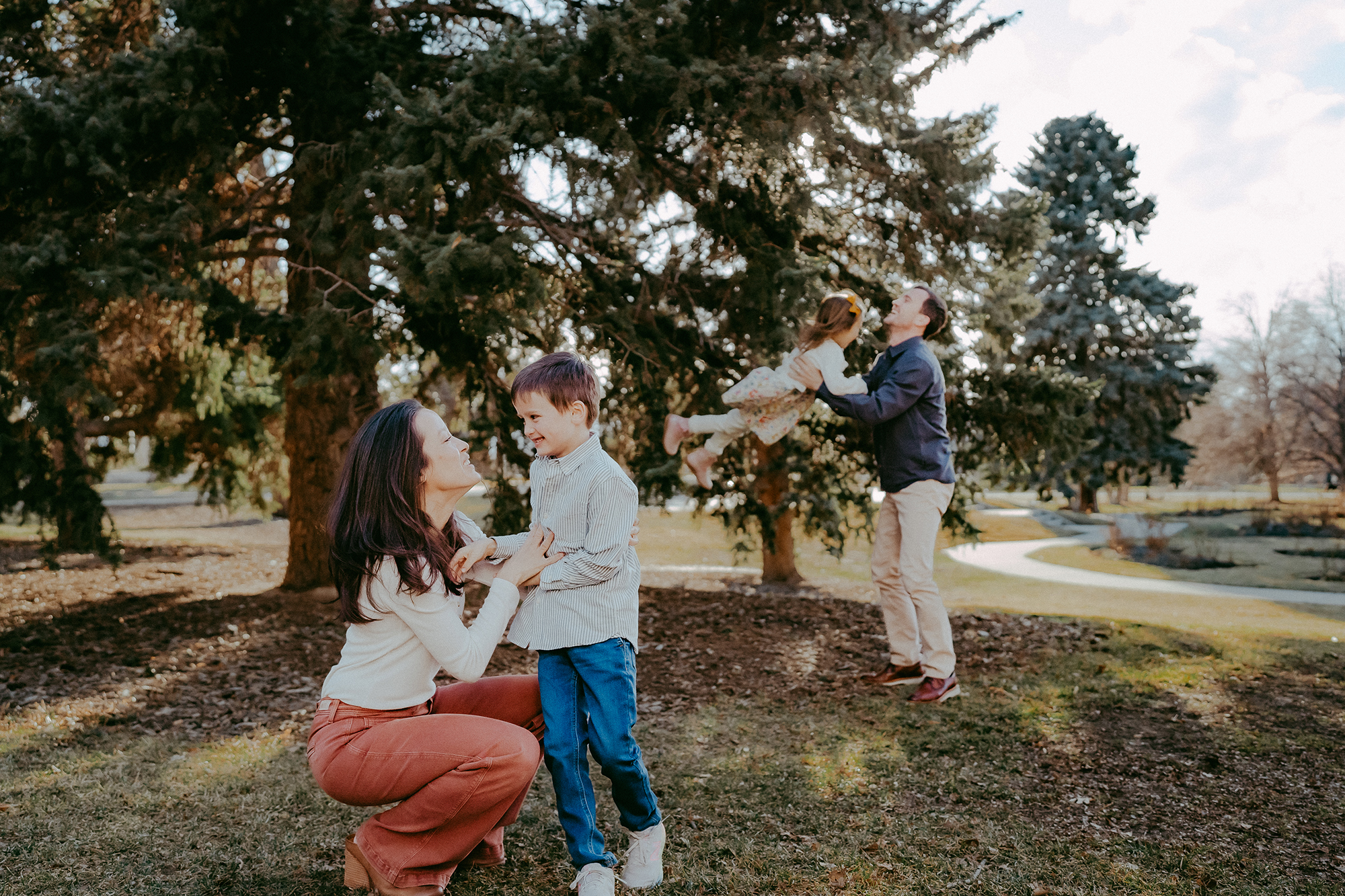 Denver family photographer captures mother talking to child while father plays with child