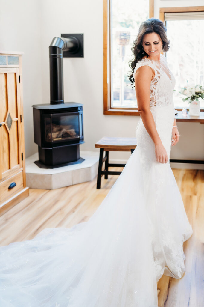 Colorado Elopement Photographer captures bride wearing beautiful wedding gown looking at train