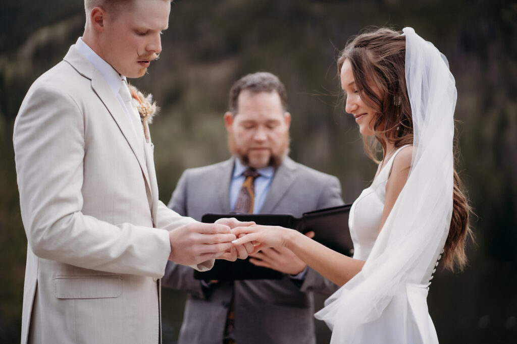 Colorado Elopement Photographer captures groom placing ring on bride's finger