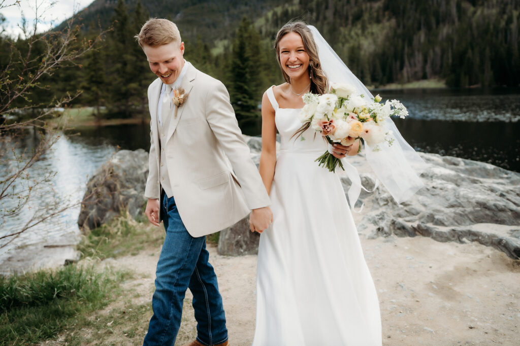 Colorado Elopement Photographer captures bride and groom walking while bride holds bouquet