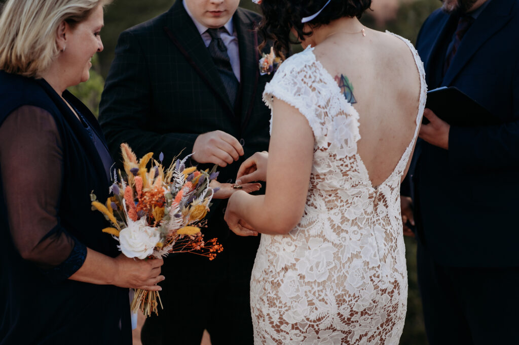 Denver Wedding Photographer captures groom putting ring on bride