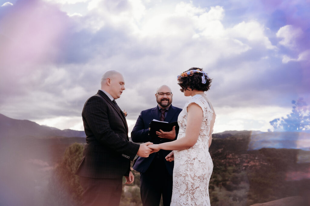 Denver Wedding Photographer captures bride and groom holding hands during elopement ceremony at the Garden of the Gods