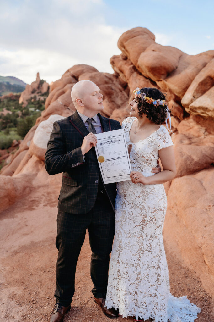 Denver Wedding Photographer captures couple smiling at one another holding marriage license