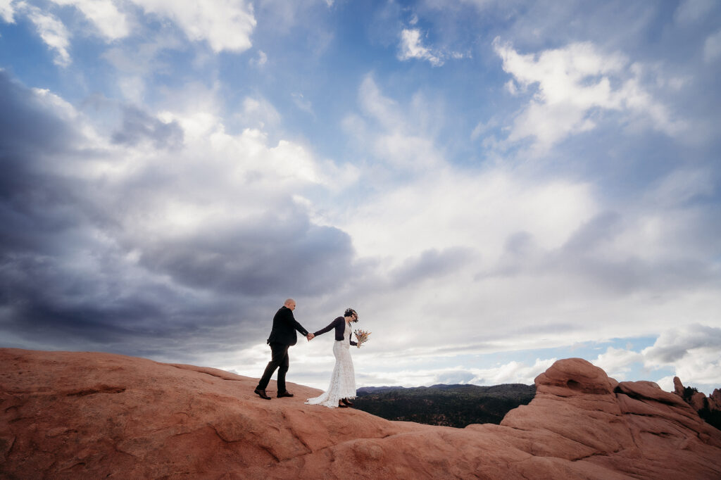 Denver Elopement Photographer captures couple holding hands and walking through Garden of the Gods